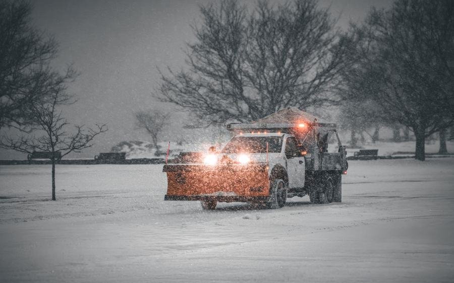Snow plow truck clearing a residential street in winter